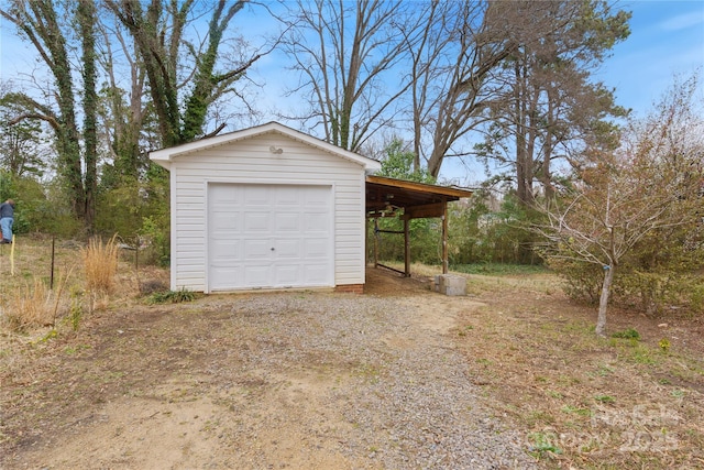 garage with a detached garage and dirt driveway