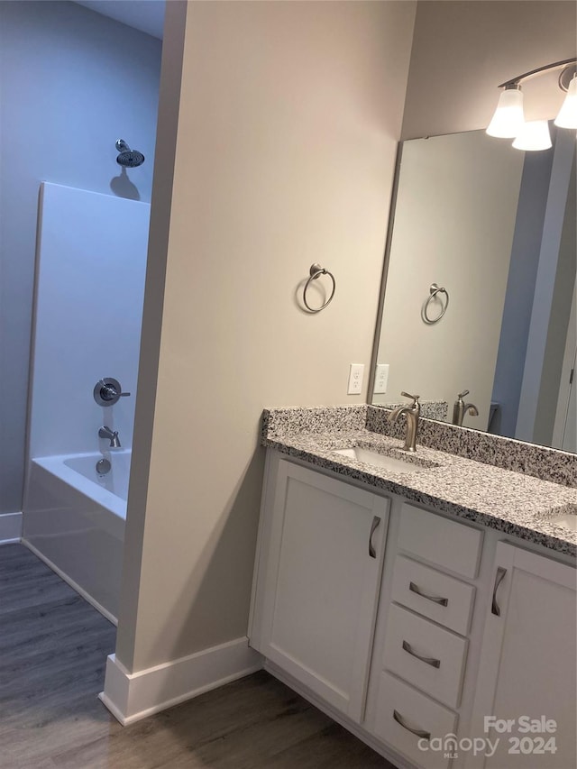 bathroom featuring vanity, wood-type flooring, and bathtub / shower combination