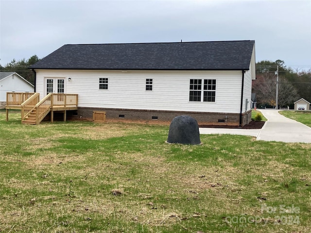 rear view of house with a lawn and a deck