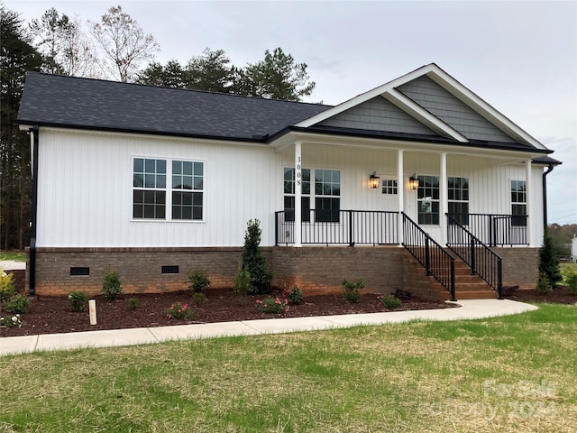 view of front of property with covered porch and a front yard