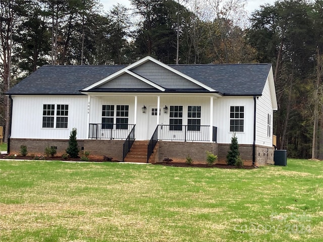 view of front facade featuring a front lawn, covered porch, and central AC unit