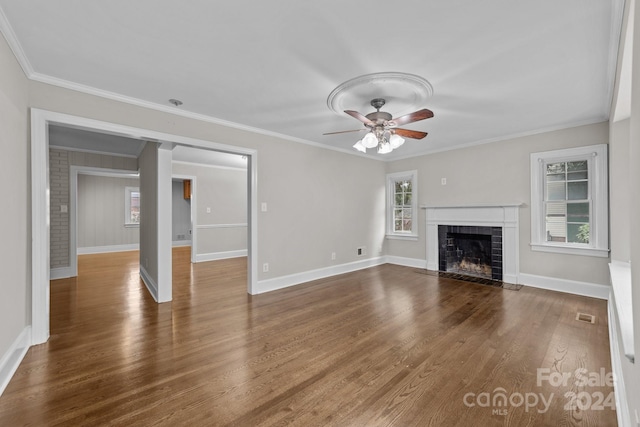 unfurnished living room featuring a fireplace, ornamental molding, ceiling fan, and dark wood-type flooring