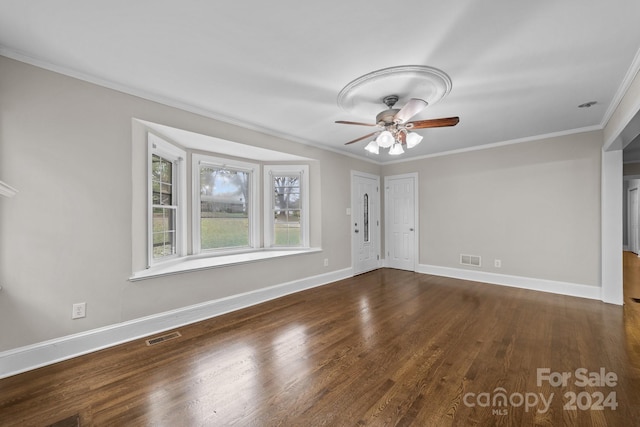 spare room with crown molding, ceiling fan, and dark wood-type flooring