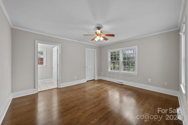 unfurnished room with dark hardwood / wood-style floors, a wealth of natural light, and ornamental molding