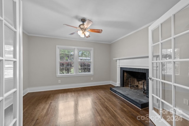 unfurnished living room featuring dark hardwood / wood-style flooring, a brick fireplace, ceiling fan, and crown molding