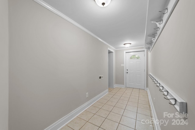 doorway featuring crown molding and light tile patterned floors