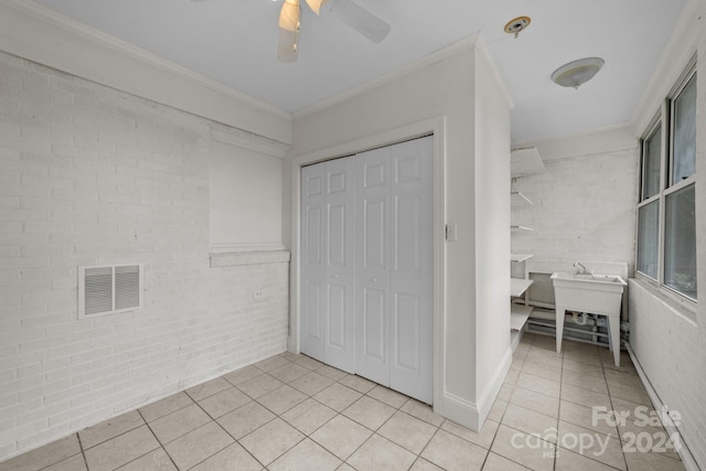 unfurnished bedroom featuring ceiling fan, light tile patterned flooring, crown molding, and a closet