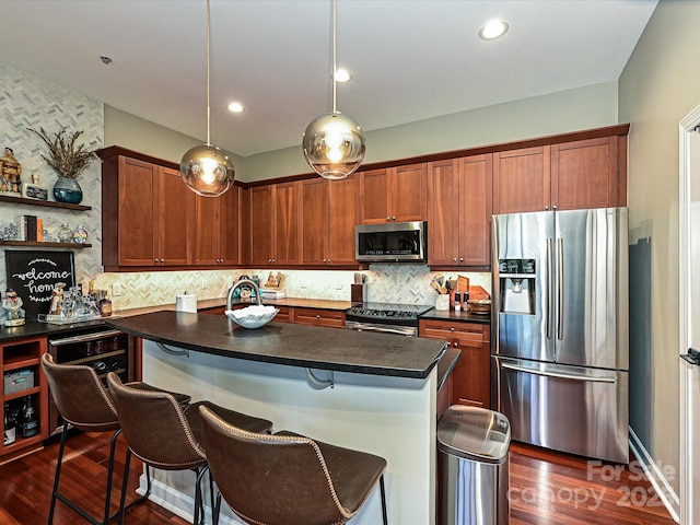 kitchen with hanging light fixtures, a breakfast bar area, decorative backsplash, a kitchen island, and appliances with stainless steel finishes