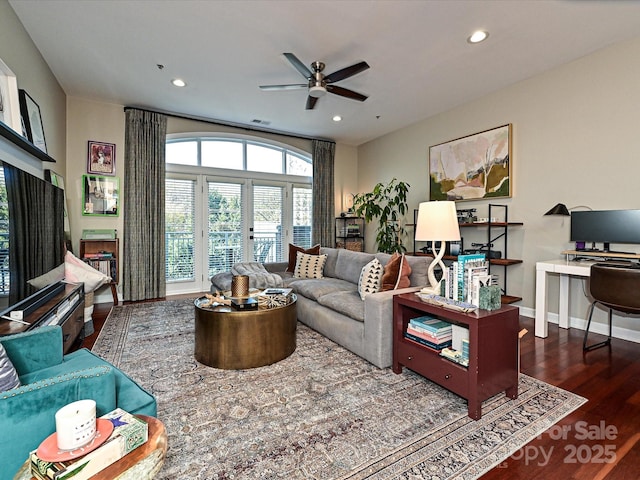 living room featuring ceiling fan and dark hardwood / wood-style flooring