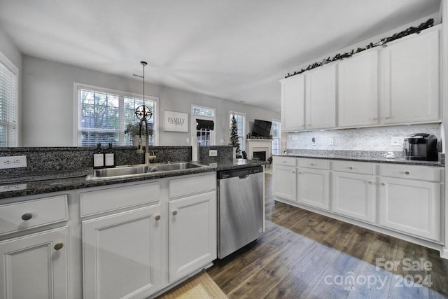 kitchen with dark wood-type flooring, white cabinets, sink, stainless steel dishwasher, and dark stone countertops