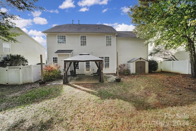 rear view of property with a gazebo, a patio, and a storage shed