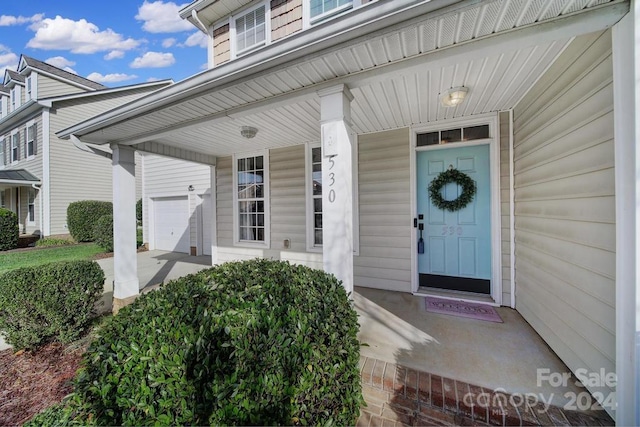 entrance to property featuring a porch and a garage