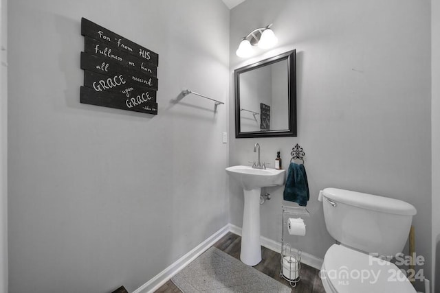 bathroom featuring hardwood / wood-style flooring and toilet