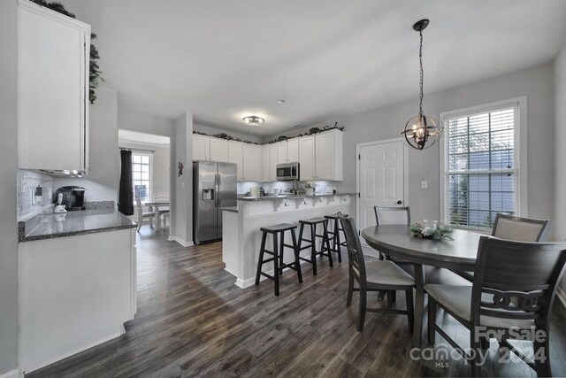 dining area with dark hardwood / wood-style flooring and a chandelier