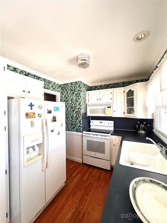 kitchen featuring dark hardwood / wood-style floors, sink, crown molding, white appliances, and white cabinetry