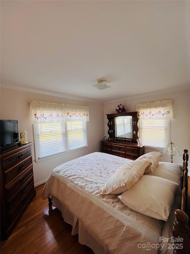 bedroom with dark wood-type flooring and crown molding