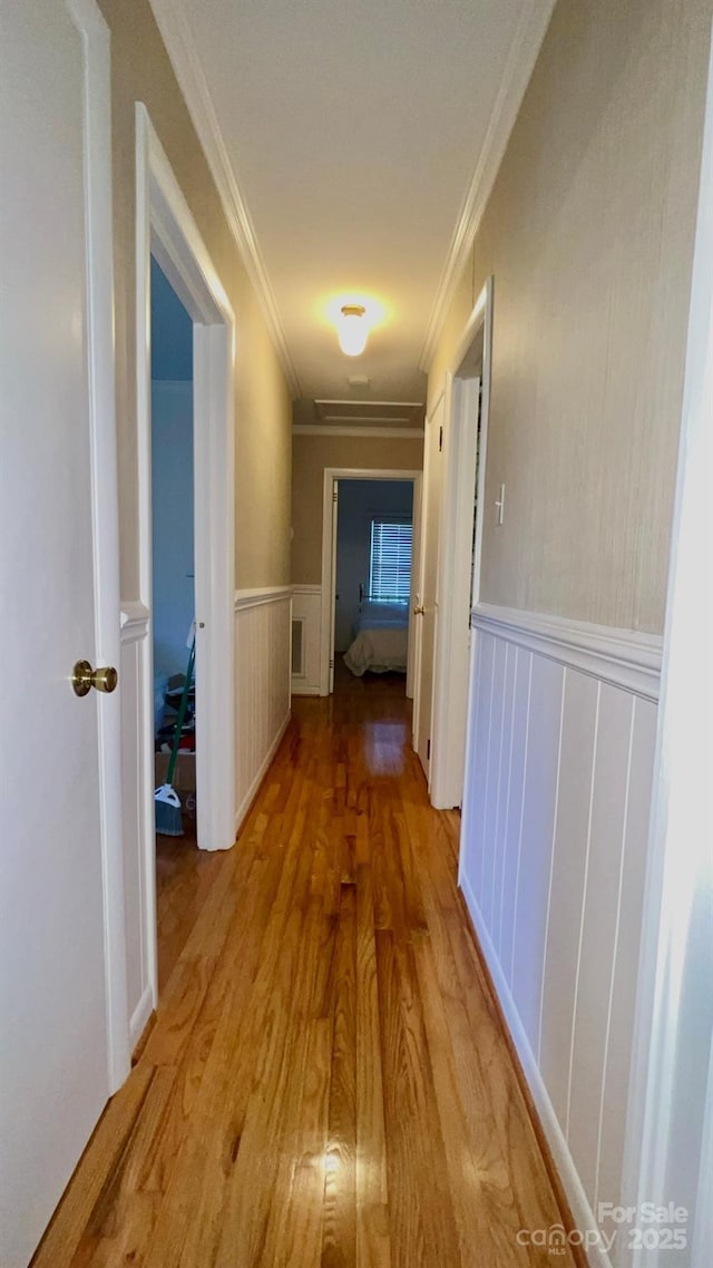 corridor featuring crown molding and light hardwood / wood-style floors