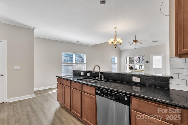 kitchen featuring brown cabinetry, dishwasher, light wood-style flooring, a sink, and backsplash