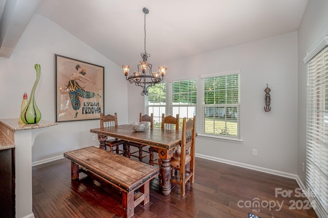 dining area with dark hardwood / wood-style flooring, a chandelier, and vaulted ceiling