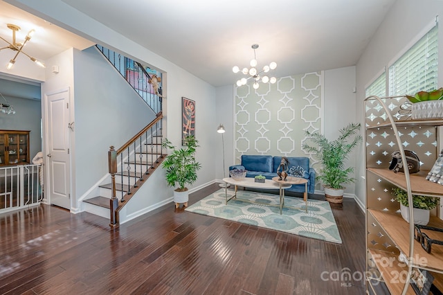 sitting room with dark wood-type flooring and an inviting chandelier