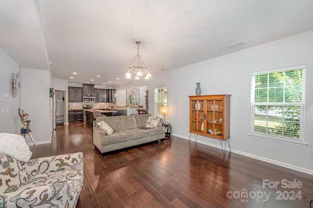 living room with dark hardwood / wood-style flooring and an inviting chandelier