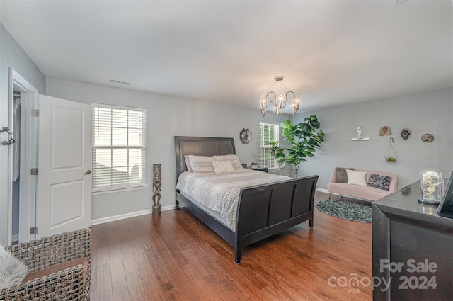 bedroom with a notable chandelier and dark hardwood / wood-style floors