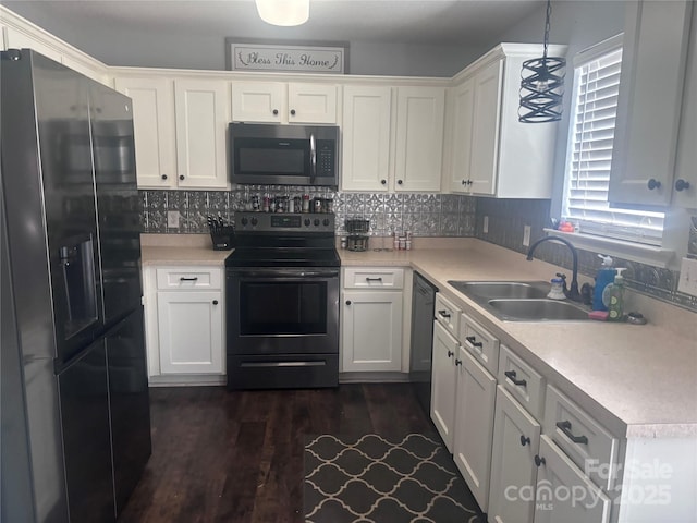 kitchen featuring appliances with stainless steel finishes, sink, white cabinets, hanging light fixtures, and decorative backsplash