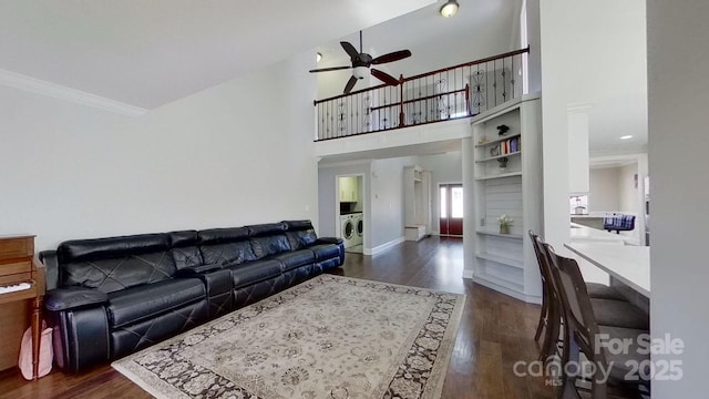 living room with ceiling fan, dark hardwood / wood-style floors, crown molding, and washer / clothes dryer