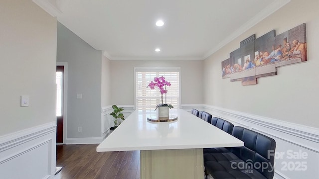 dining room featuring dark hardwood / wood-style flooring, crown molding, and breakfast area