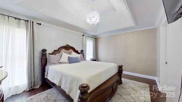 bedroom with a tray ceiling, dark hardwood / wood-style floors, crown molding, and an inviting chandelier