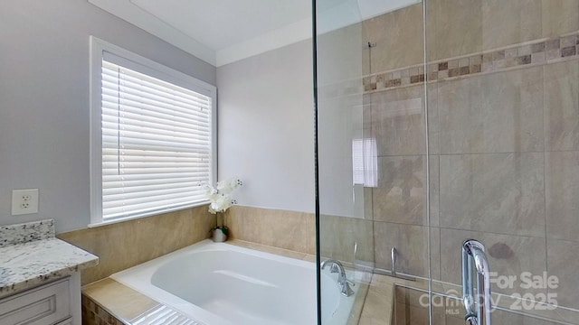 bathroom with a relaxing tiled tub and vanity