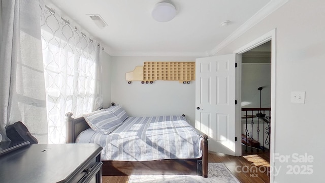 bedroom with ornamental molding and hardwood / wood-style floors