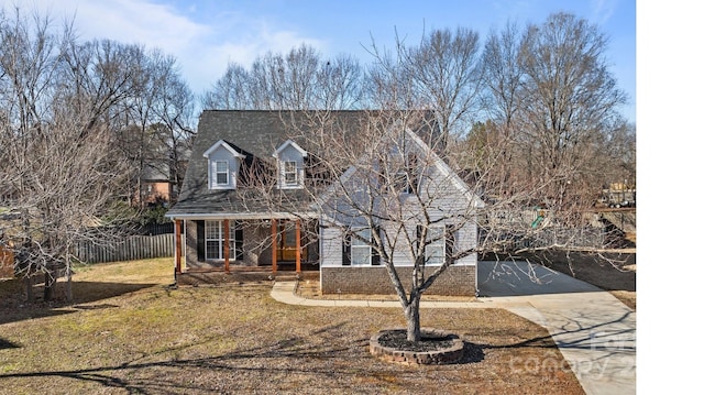 cape cod home with a front yard and a porch