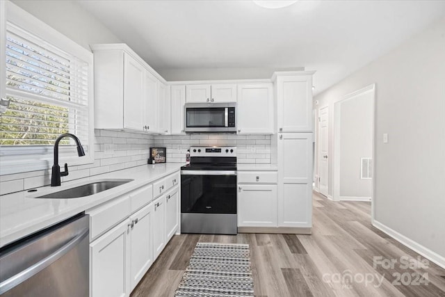 kitchen featuring white cabinets, light hardwood / wood-style floors, sink, and stainless steel appliances