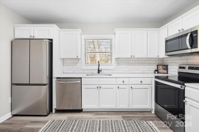 624 Dundeen Dr, Gastonia, NC 28052 - kitchen with stainless steel appliances, a sink, light wood-style flooring, and tasteful backsplash
