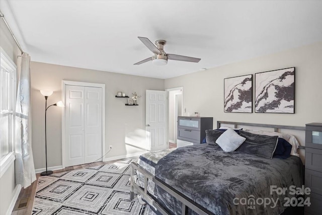 bedroom featuring ceiling fan, a closet, and light hardwood / wood-style flooring