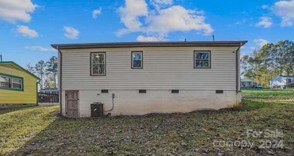 rear view of property with a lawn and central AC