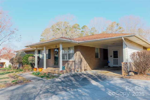 ranch-style home featuring driveway, a carport, a porch, and brick siding