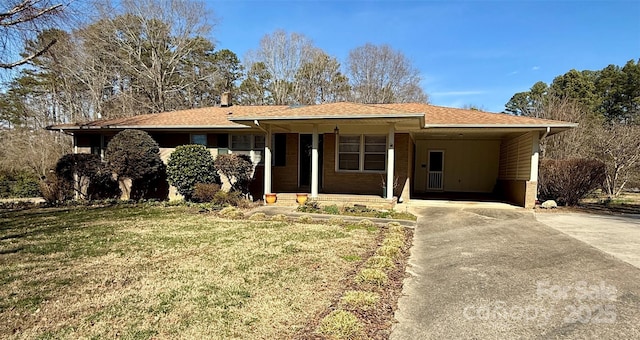 ranch-style home featuring an attached carport, a front lawn, and concrete driveway