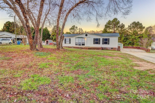 view of front of house with a garage, a lawn, and an outdoor structure