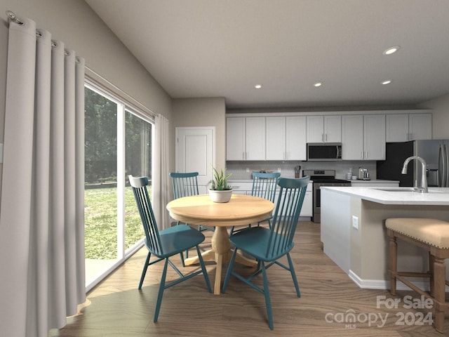 dining area featuring sink and light hardwood / wood-style flooring