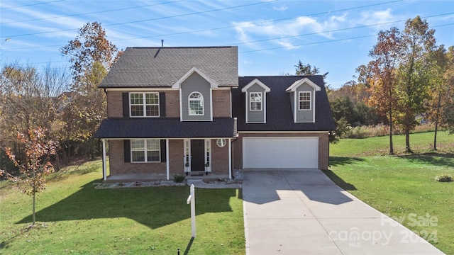 view of front of house with covered porch, a garage, and a front yard