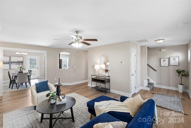 living room with light hardwood / wood-style flooring and ceiling fan with notable chandelier