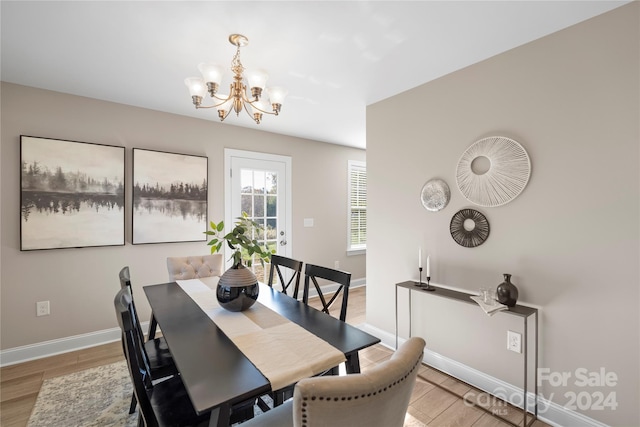 dining area featuring light hardwood / wood-style floors and an inviting chandelier