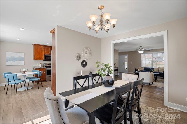 dining room featuring light hardwood / wood-style floors and ceiling fan with notable chandelier