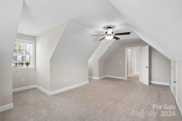 additional living space with light colored carpet, ceiling fan, and lofted ceiling