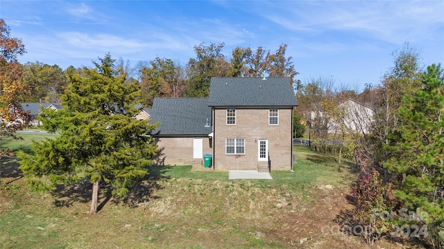 rear view of house with a lawn and a patio