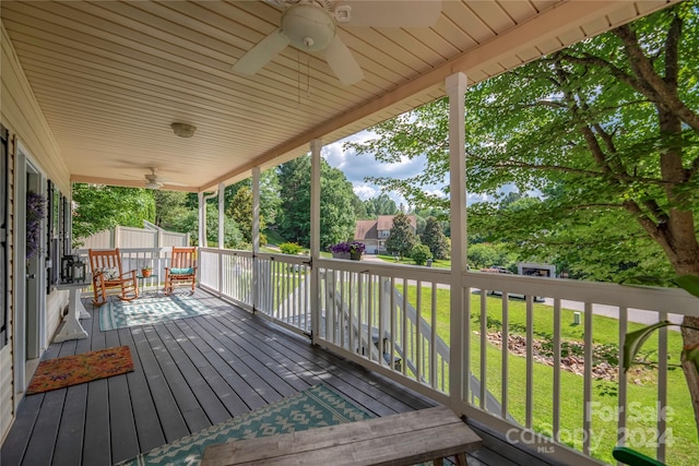 wooden deck featuring covered porch, a yard, and ceiling fan