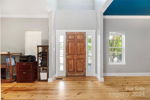 entrance foyer with crown molding and light hardwood / wood-style floors