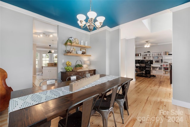 dining area featuring crown molding, ceiling fan with notable chandelier, and light wood-type flooring